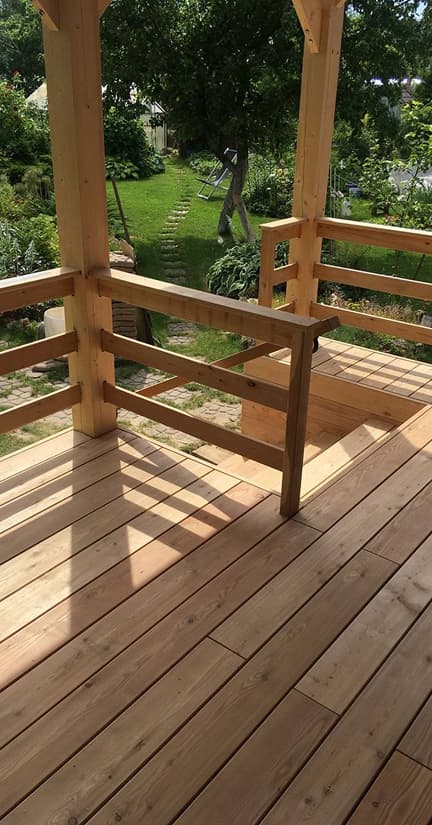 Elevated wooden deck with horizontal railing.