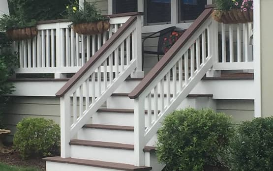 White painted stairs with decorative railings leading to a porch.