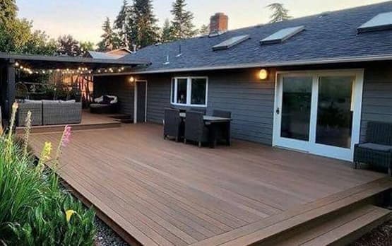 Spacious backyard deck with outdoor furniture next to a sliding glass door.